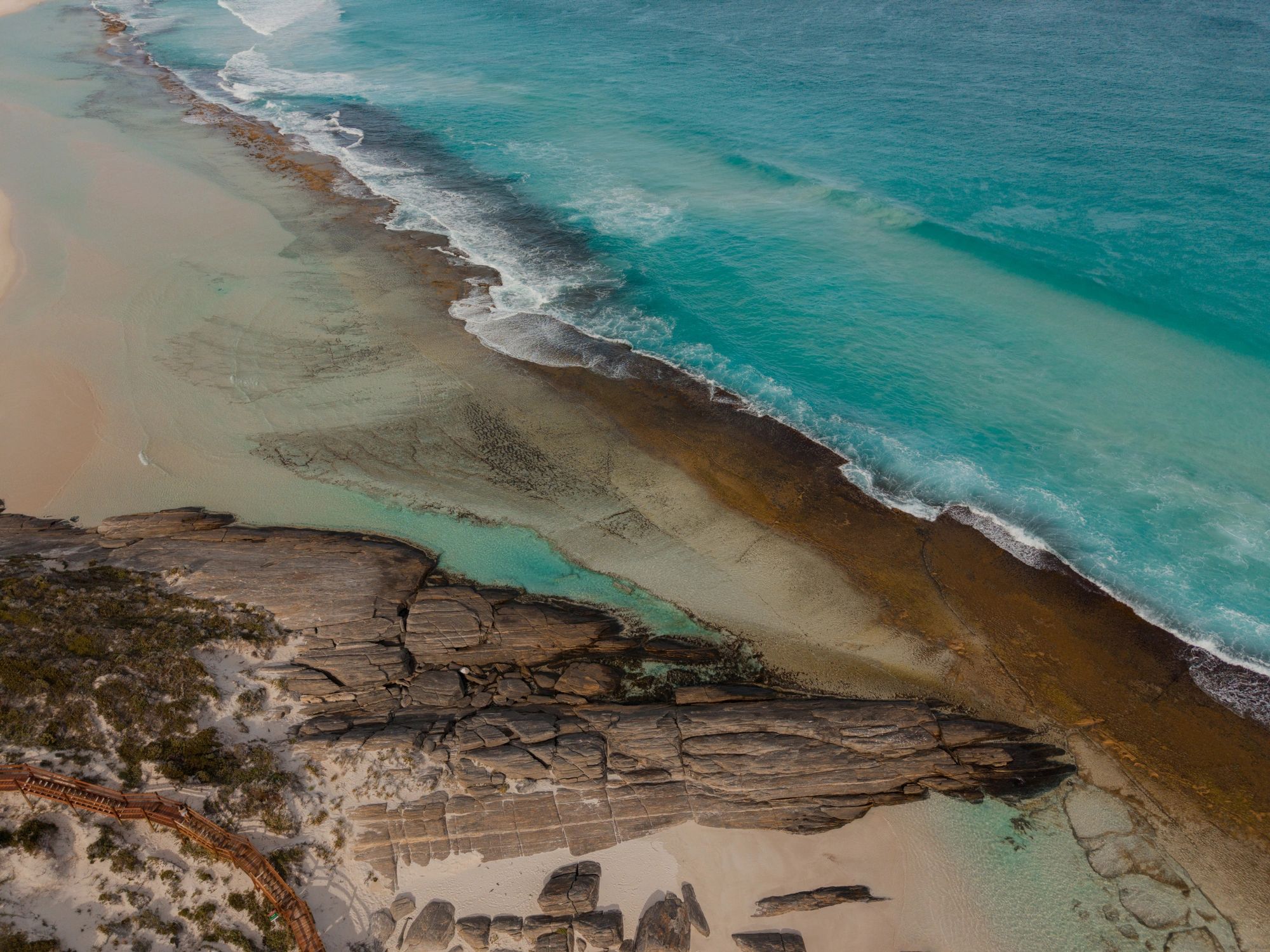 Turquoise ocean waves along a sandy beach